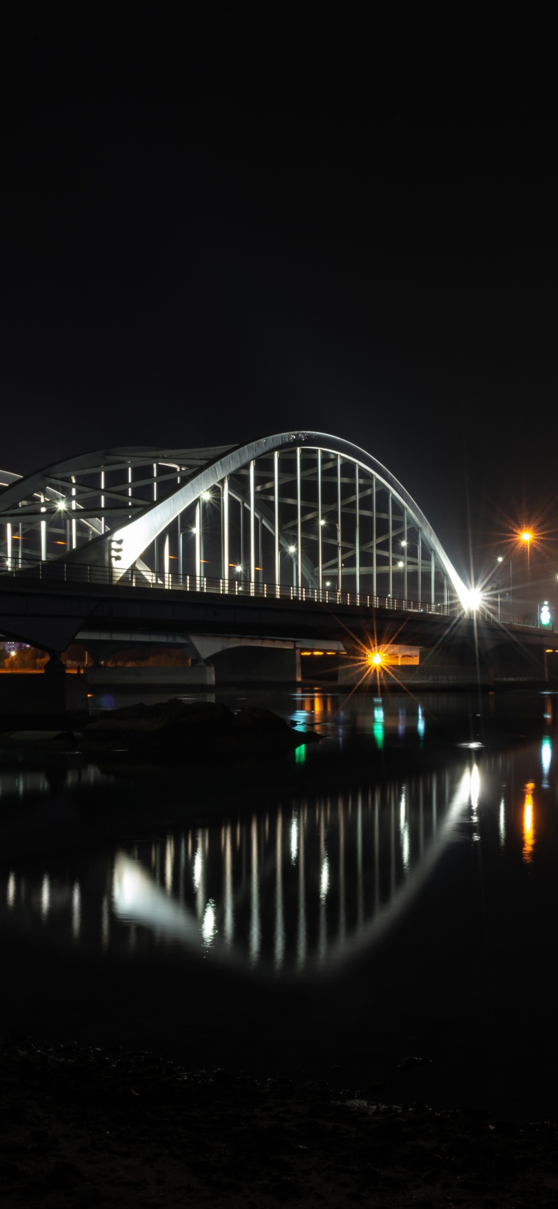 Bridge Over Water During Night Time. Wallpaper in 1125x2436 Resolution