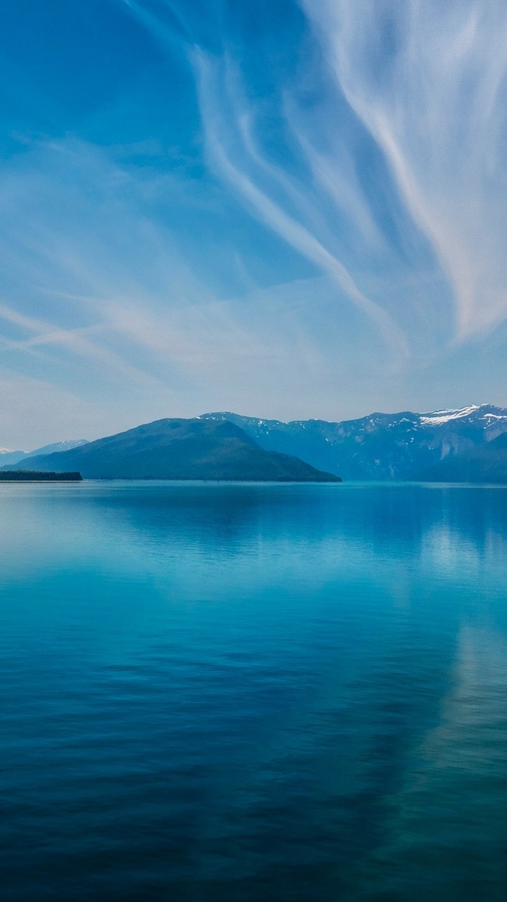 Blue Body of Water Near Mountain Under Blue Sky During Daytime. Wallpaper in 720x1280 Resolution