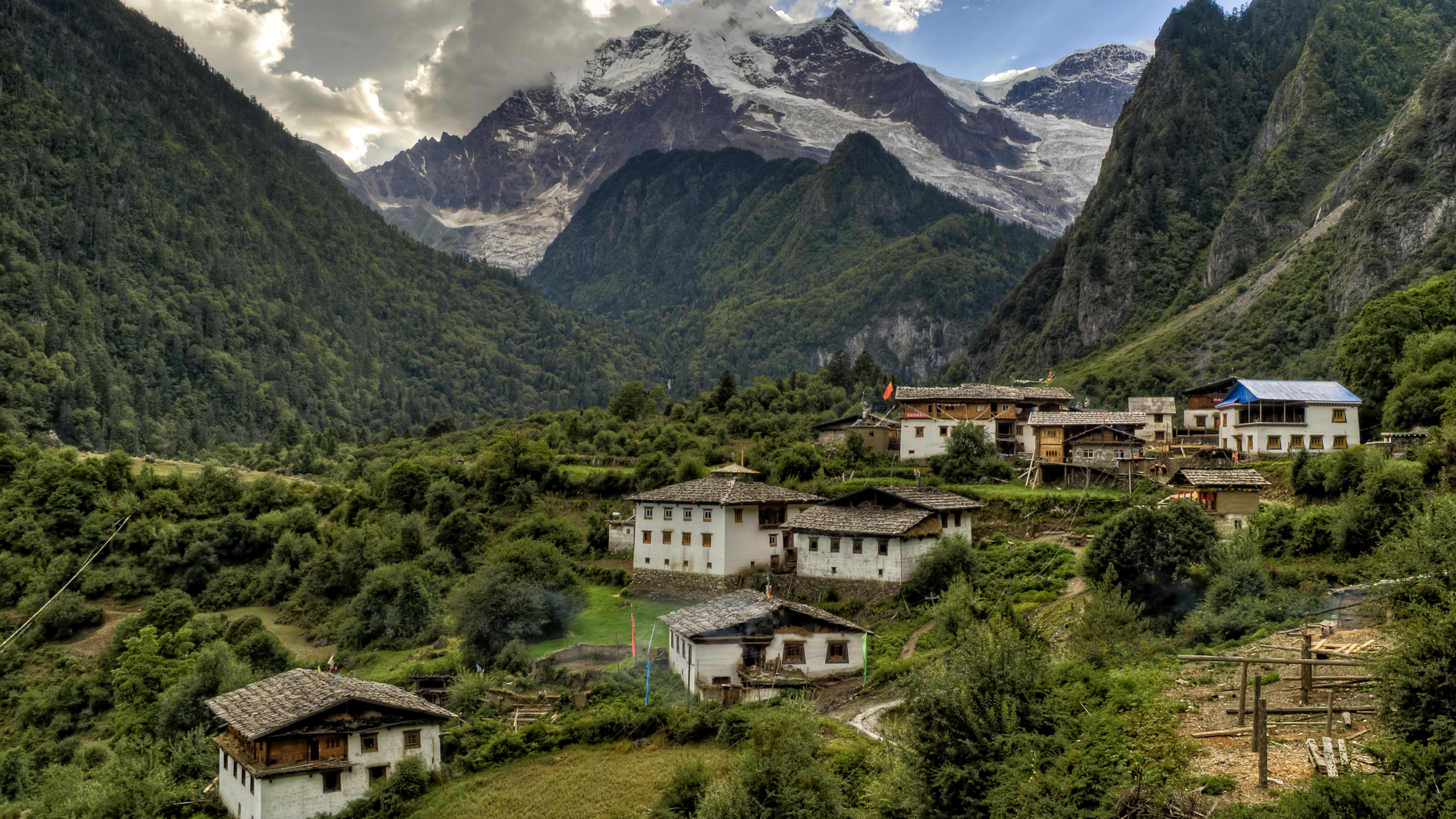 White and Brown Concrete Building Near Green Trees and Mountains During Daytime. Wallpaper in 2560x1440 Resolution