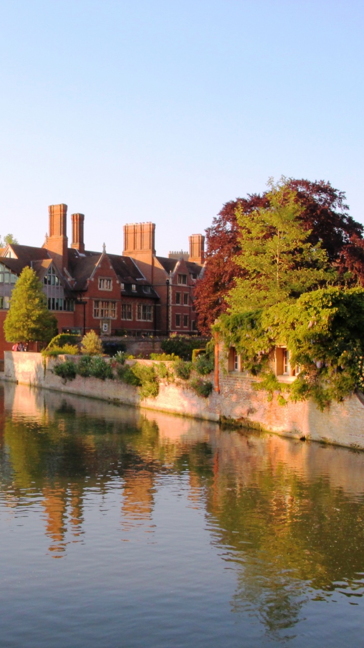 Brown Concrete Building Near Green Trees and Body of Water During Daytime. Wallpaper in 720x1280 Resolution