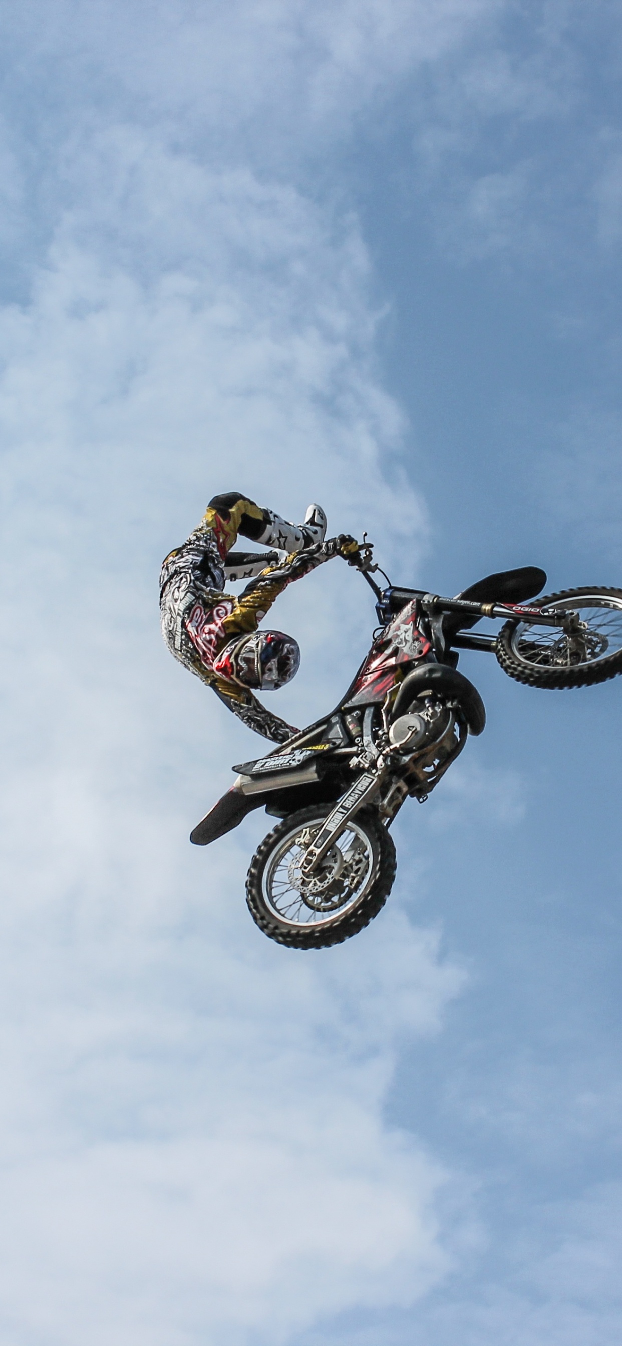 Mann, Der Tagsüber Auf Dem Fahrrad Stunts Unter Blauem Himmel Macht. Wallpaper in 1242x2688 Resolution