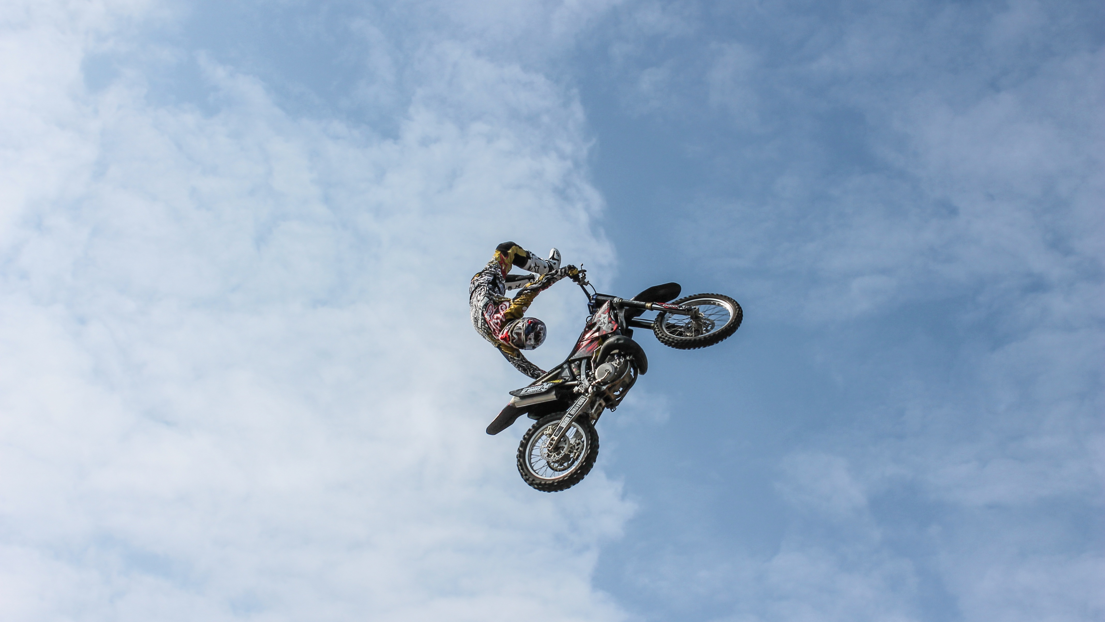 Mann, Der Tagsüber Auf Dem Fahrrad Stunts Unter Blauem Himmel Macht. Wallpaper in 3840x2160 Resolution