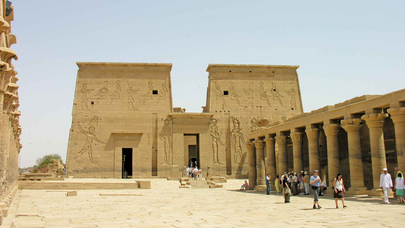 Leute, Die Tagsüber Auf Weißem Sand in Der Nähe Eines Braunen Betongebäudes Gehen. Wallpaper in 1366x768 Resolution