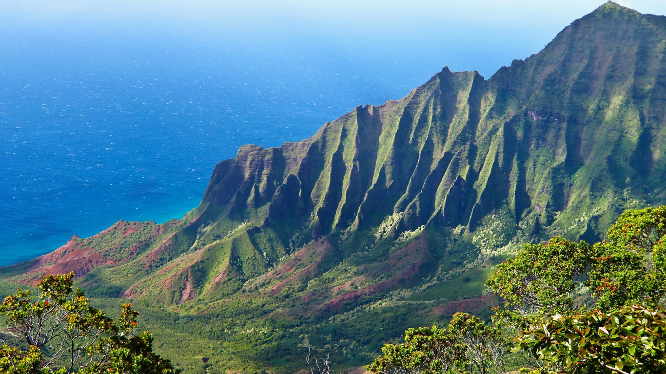 Green and Brown Mountains Beside Blue Sea Under Blue Sky During Daytime. Wallpaper in 1366x768 Resolution