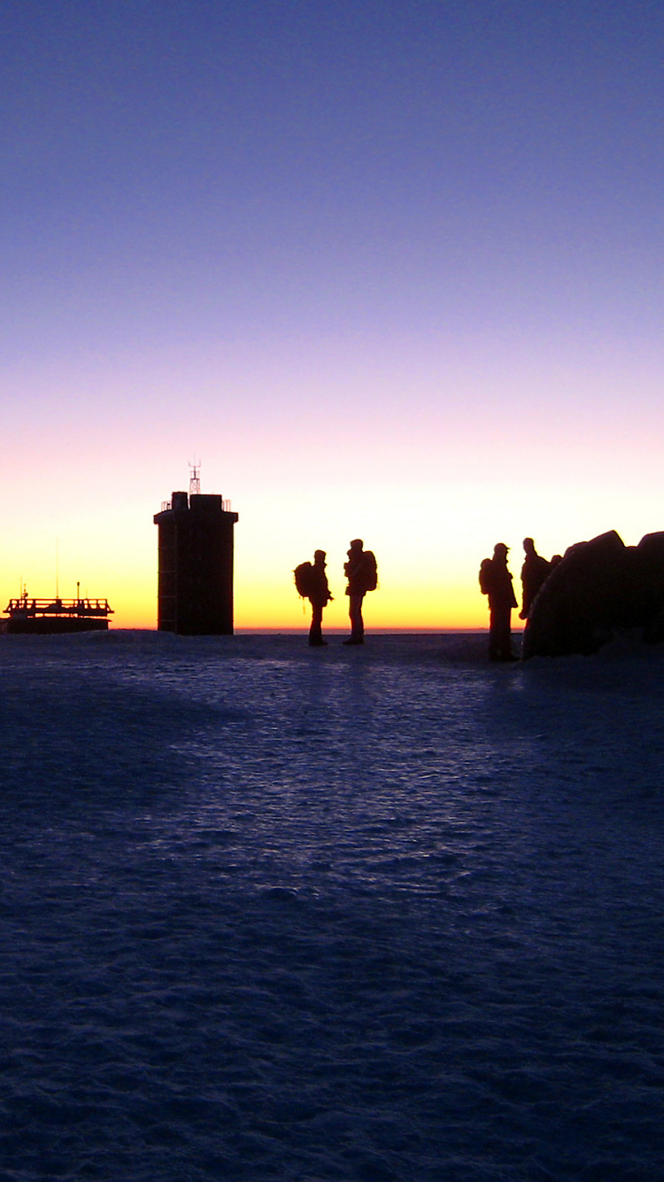 Silhouette de Personnes Sur Rock Formation Pendant le Coucher du Soleil. Wallpaper in 750x1334 Resolution