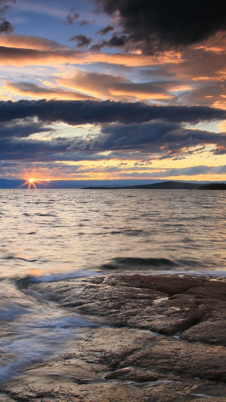 Sea Waves Crashing on Shore During Sunset. Wallpaper in 720x1280 Resolution