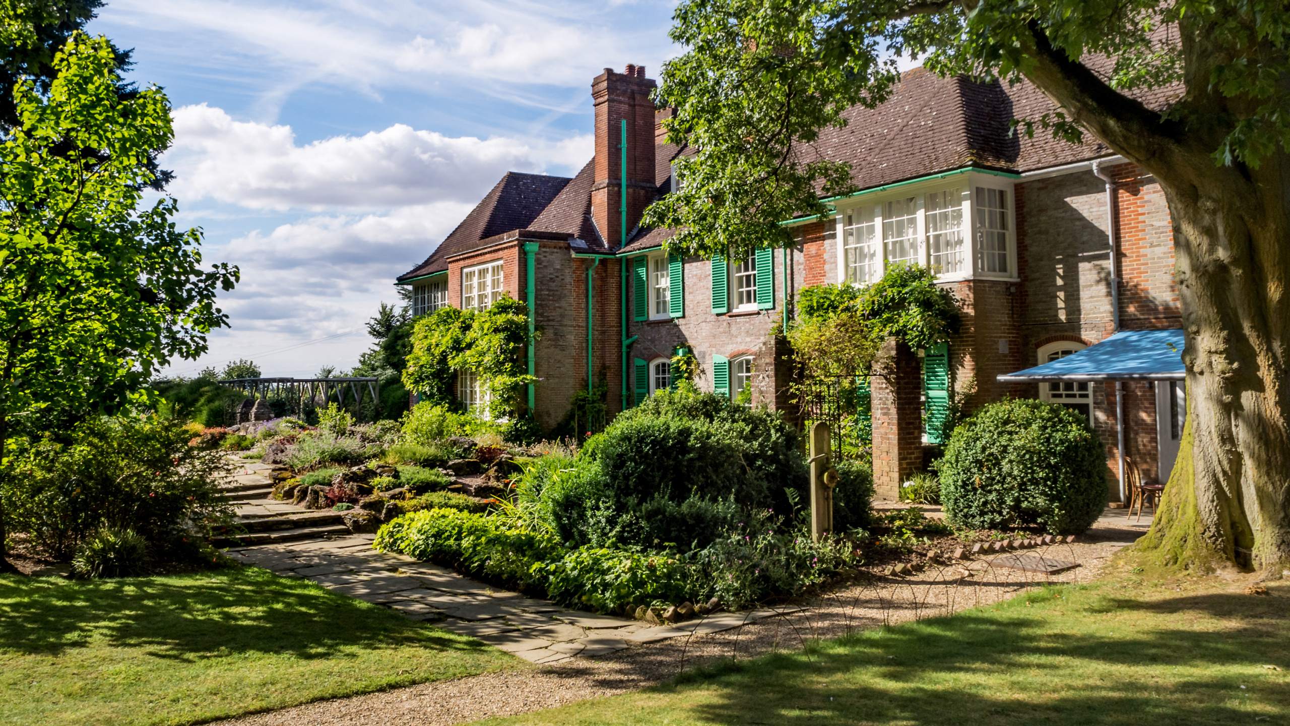 Brown and White Concrete House Near Green Trees Under Blue Sky During Daytime. Wallpaper in 2560x1440 Resolution