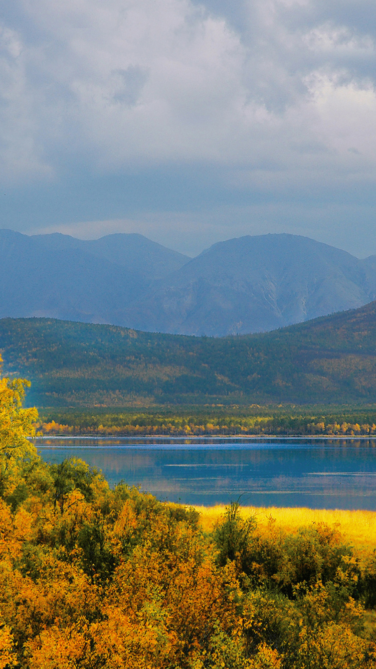 Green Mountains Near Body of Water Under Cloudy Sky During Daytime. Wallpaper in 750x1334 Resolution