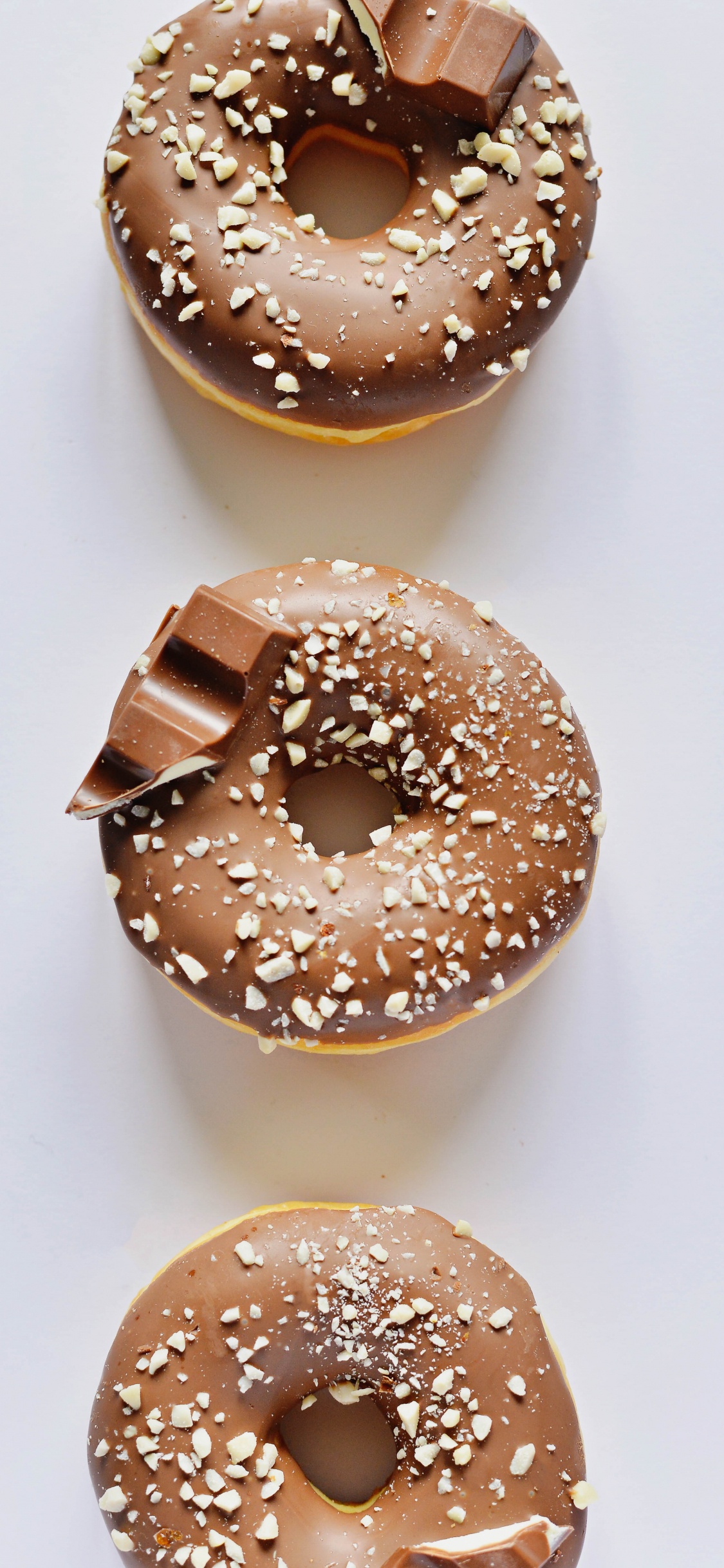 Brown Donut on White Table. Wallpaper in 1125x2436 Resolution
