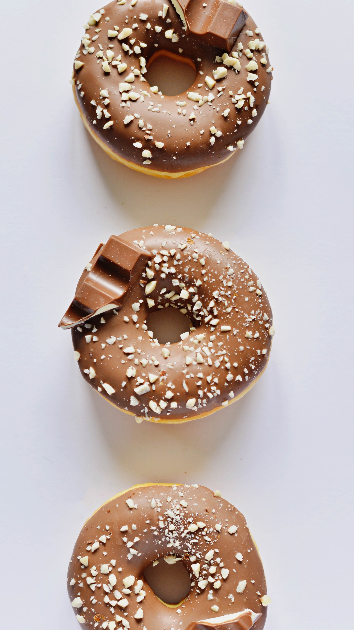 Brown Donut on White Table. Wallpaper in 1440x2560 Resolution