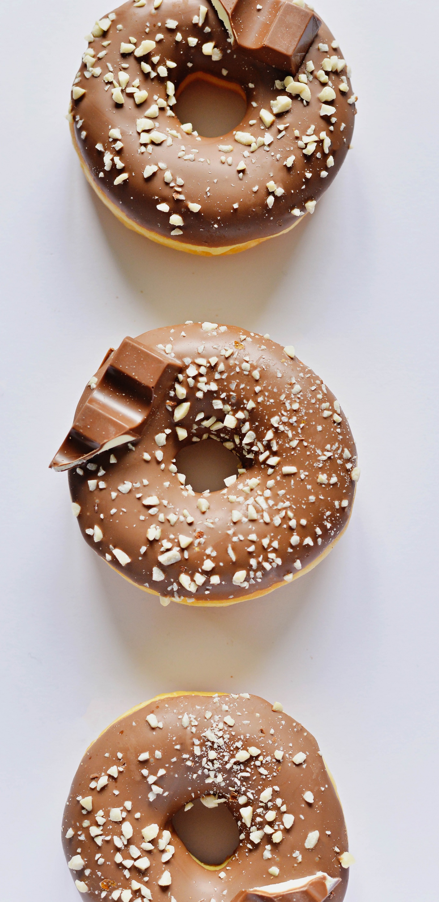 Brown Donut on White Table. Wallpaper in 1440x2960 Resolution