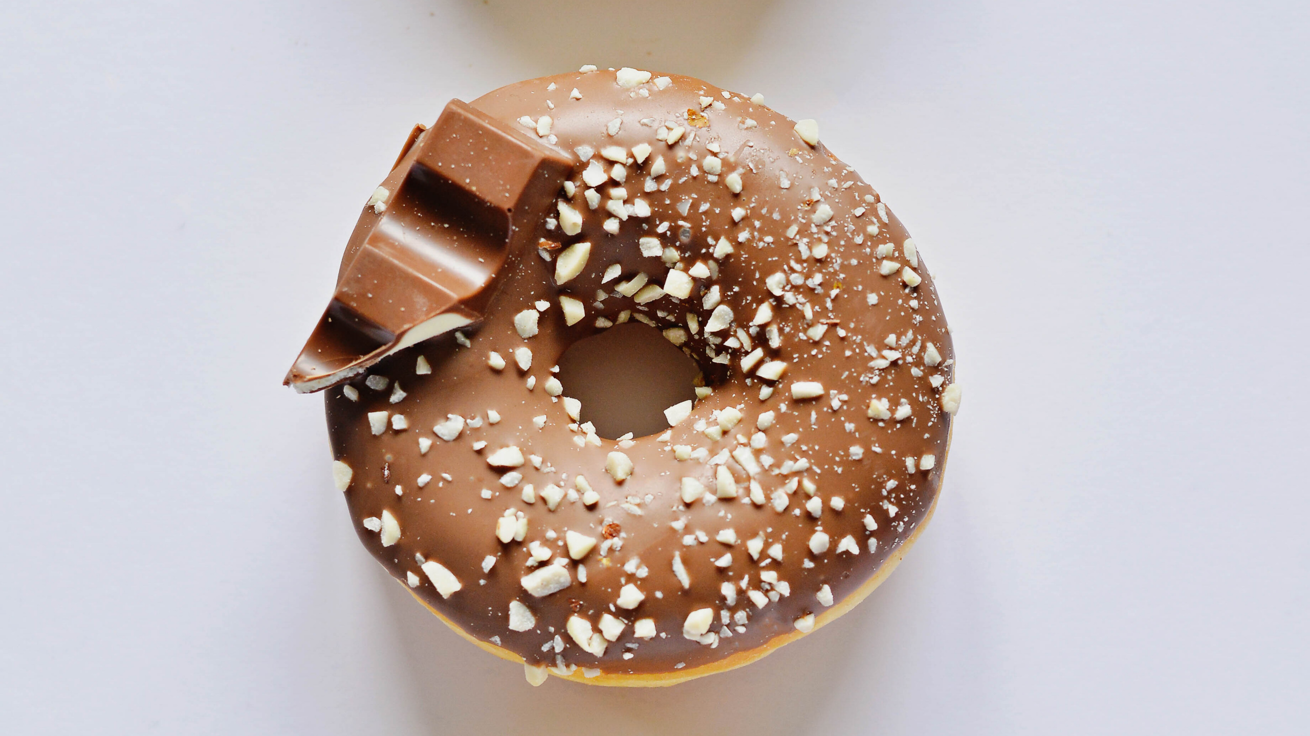 Brown Donut on White Table. Wallpaper in 2560x1440 Resolution