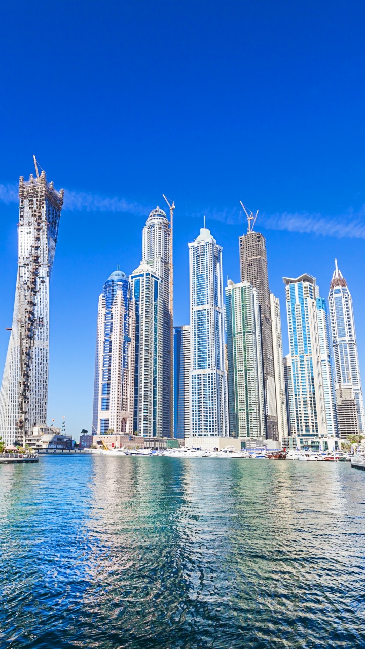 White and Blue High Rise Buildings Near Body of Water During Daytime. Wallpaper in 720x1280 Resolution