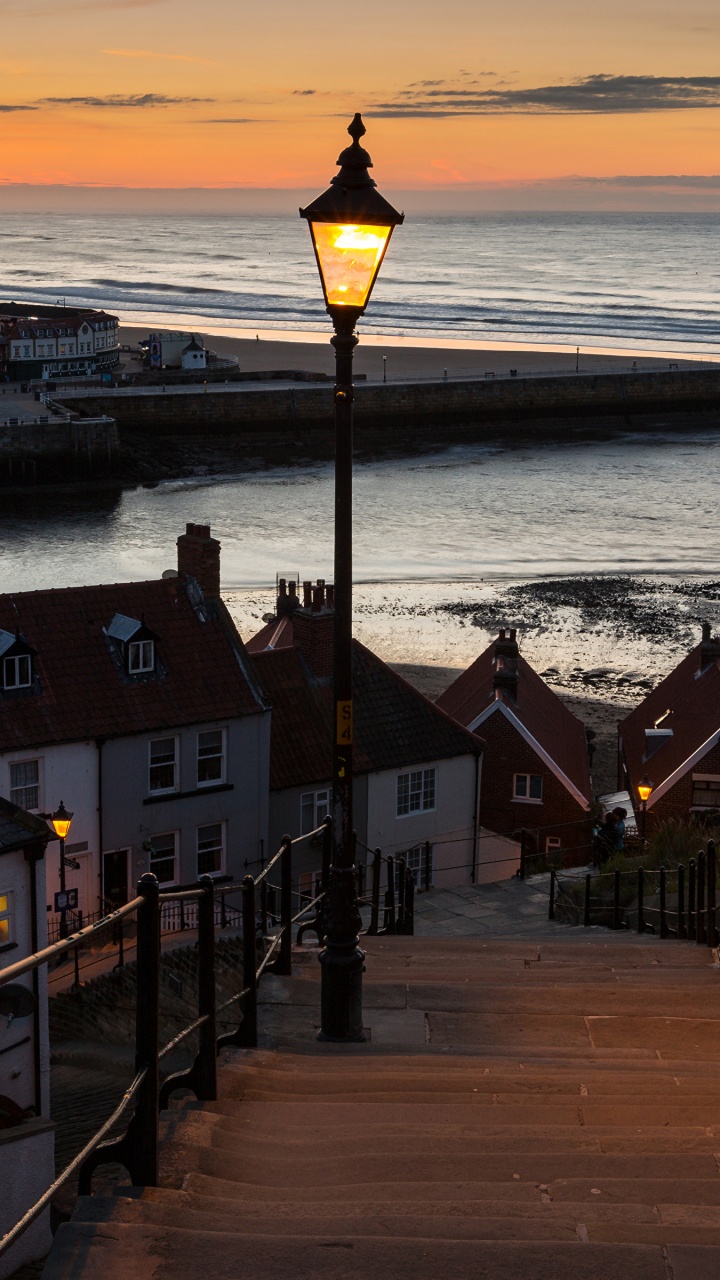 Brown Wooden Houses Near Sea During Sunset. Wallpaper in 720x1280 Resolution