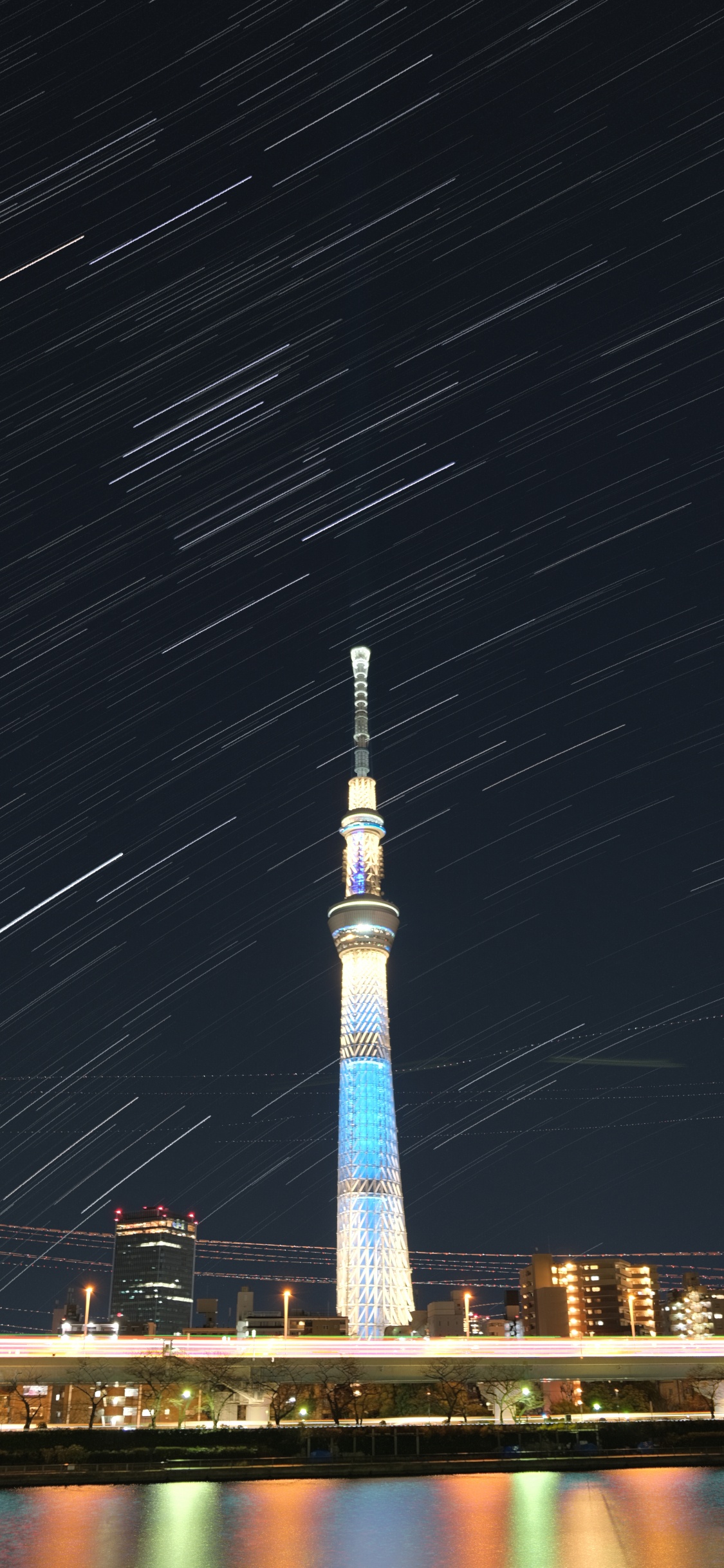 Torre Blanca y Azul Durante la Noche. Wallpaper in 1125x2436 Resolution