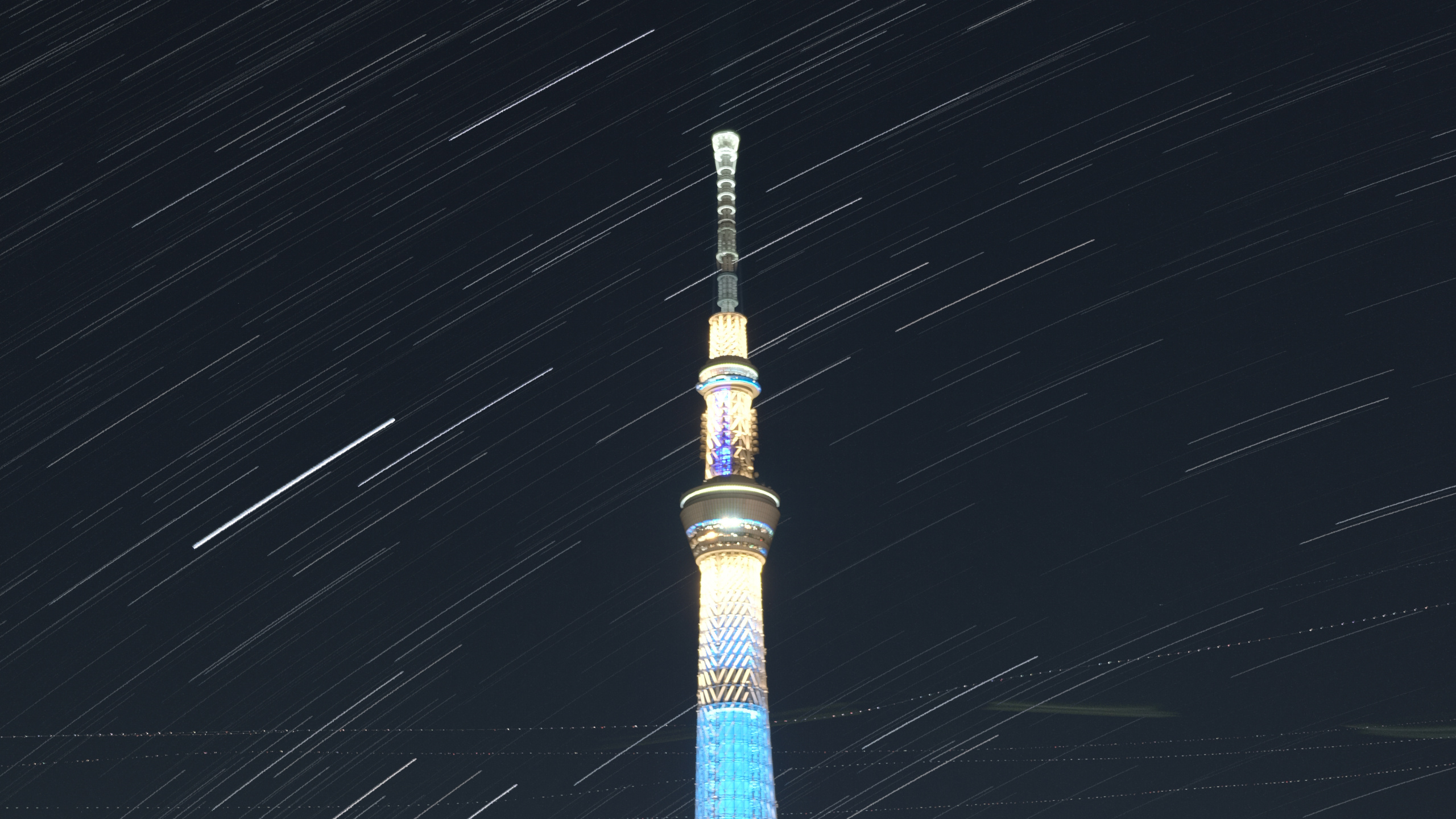 Weißer Und Blauer Turm Während Der Nacht. Wallpaper in 2560x1440 Resolution