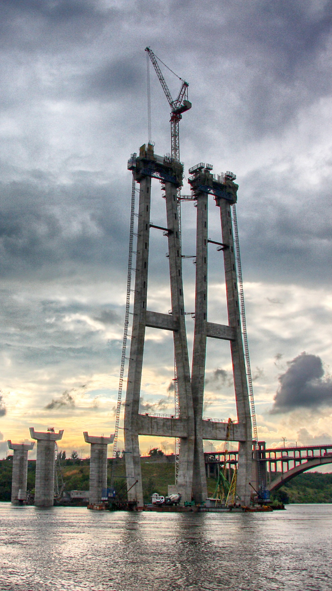Bâtiment en Béton Brun Près D'un Plan D'eau Sous un Ciel Nuageux Pendant la Journée. Wallpaper in 1080x1920 Resolution