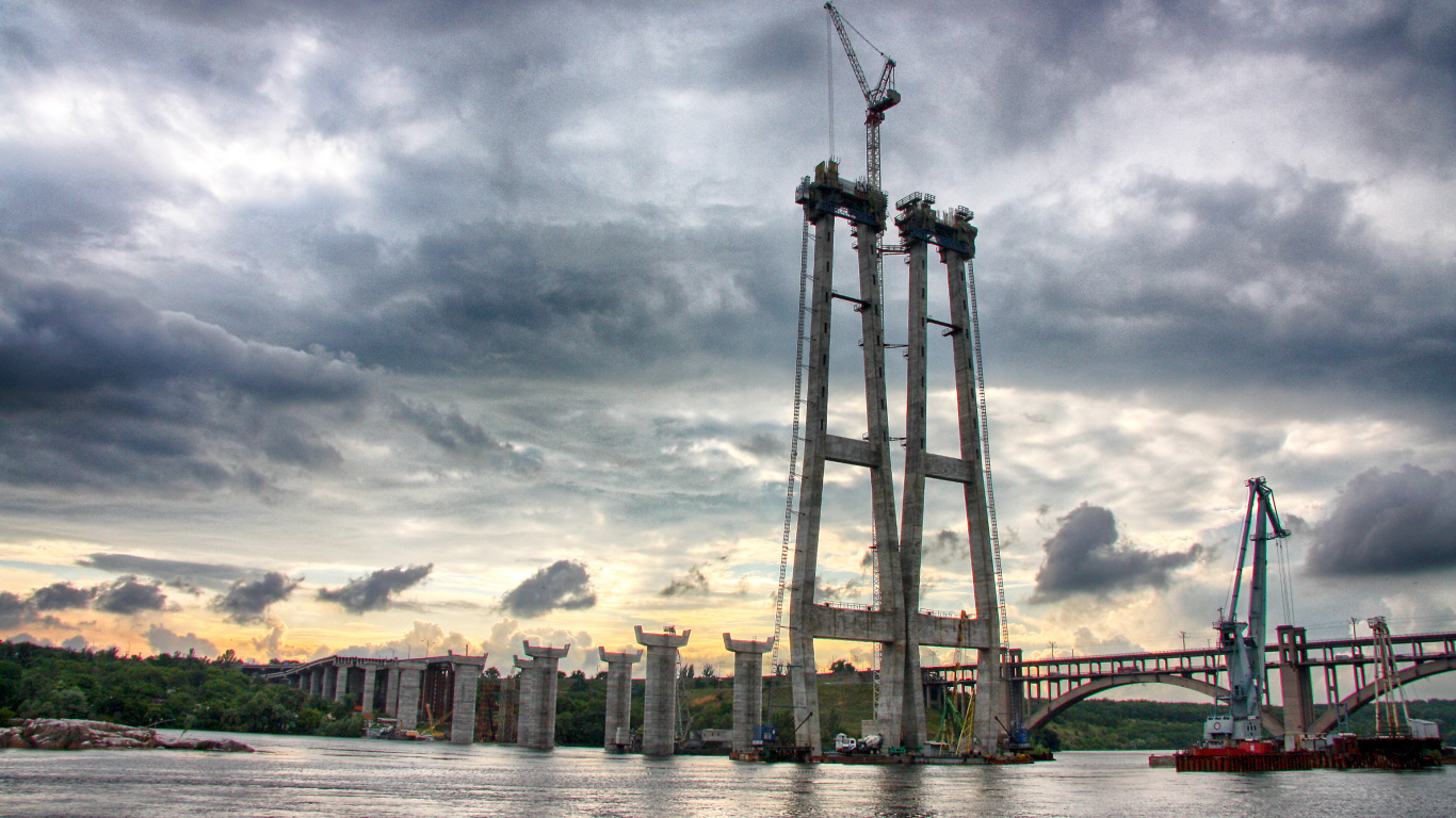 Bâtiment en Béton Brun Près D'un Plan D'eau Sous un Ciel Nuageux Pendant la Journée. Wallpaper in 1366x768 Resolution