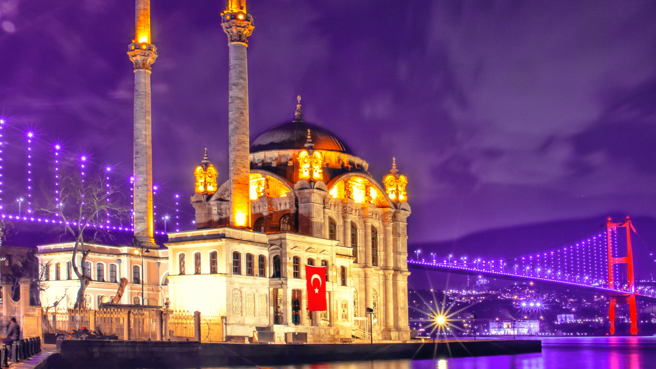 Edificio de Hormigón Marrón Cerca Del Cuerpo de Agua Durante la Noche. Wallpaper in 1280x720 Resolution