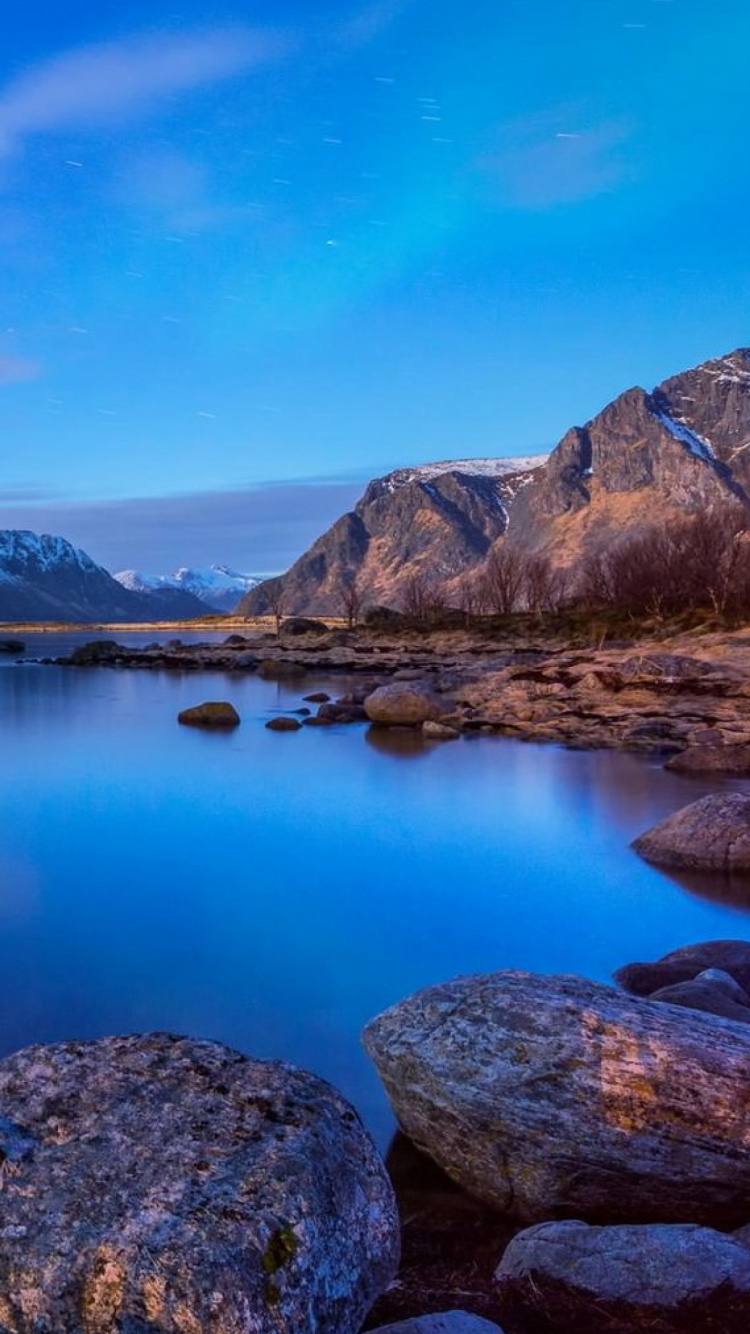 Lago Cerca de la Montaña Bajo un Cielo Azul Durante el Día. Wallpaper in 750x1334 Resolution