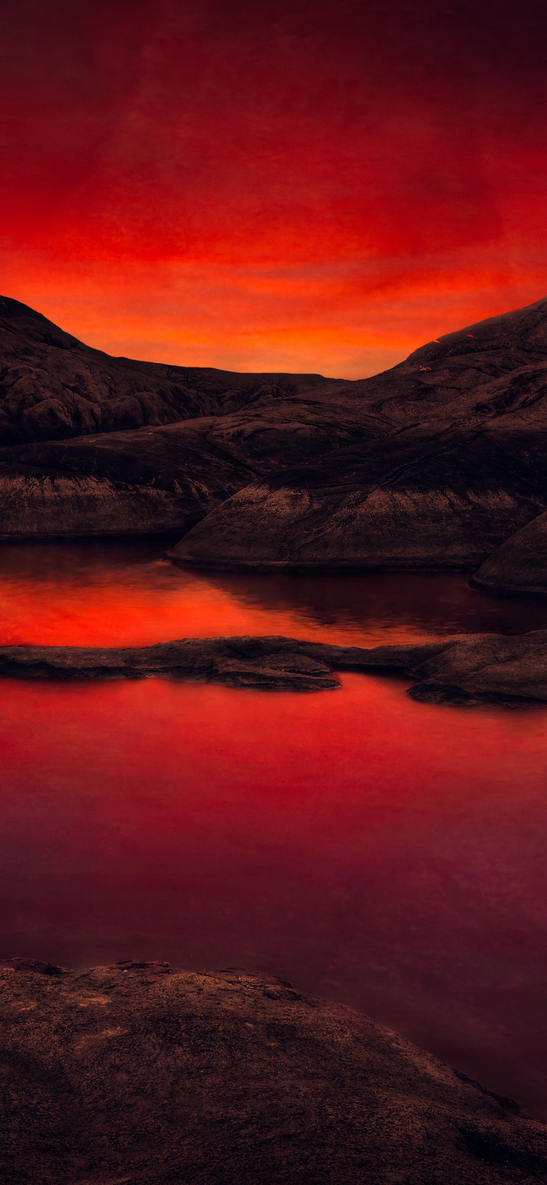 Brauner Felsiger Berg Neben Dem See Während Des Sonnenuntergangs. Wallpaper in 1125x2436 Resolution