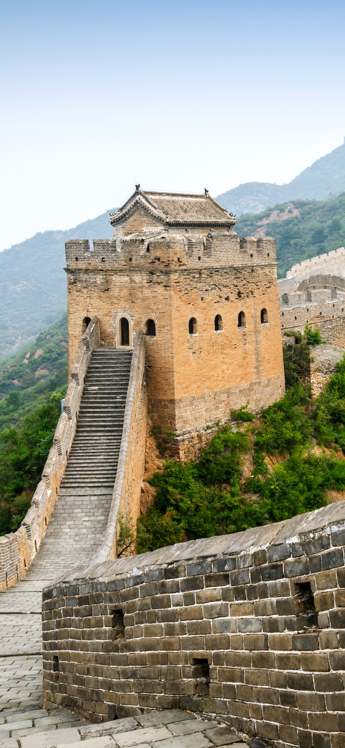 Bâtiment en Béton Brun au Sommet de la Montagne Pendant la Journée. Wallpaper in 1125x2436 Resolution