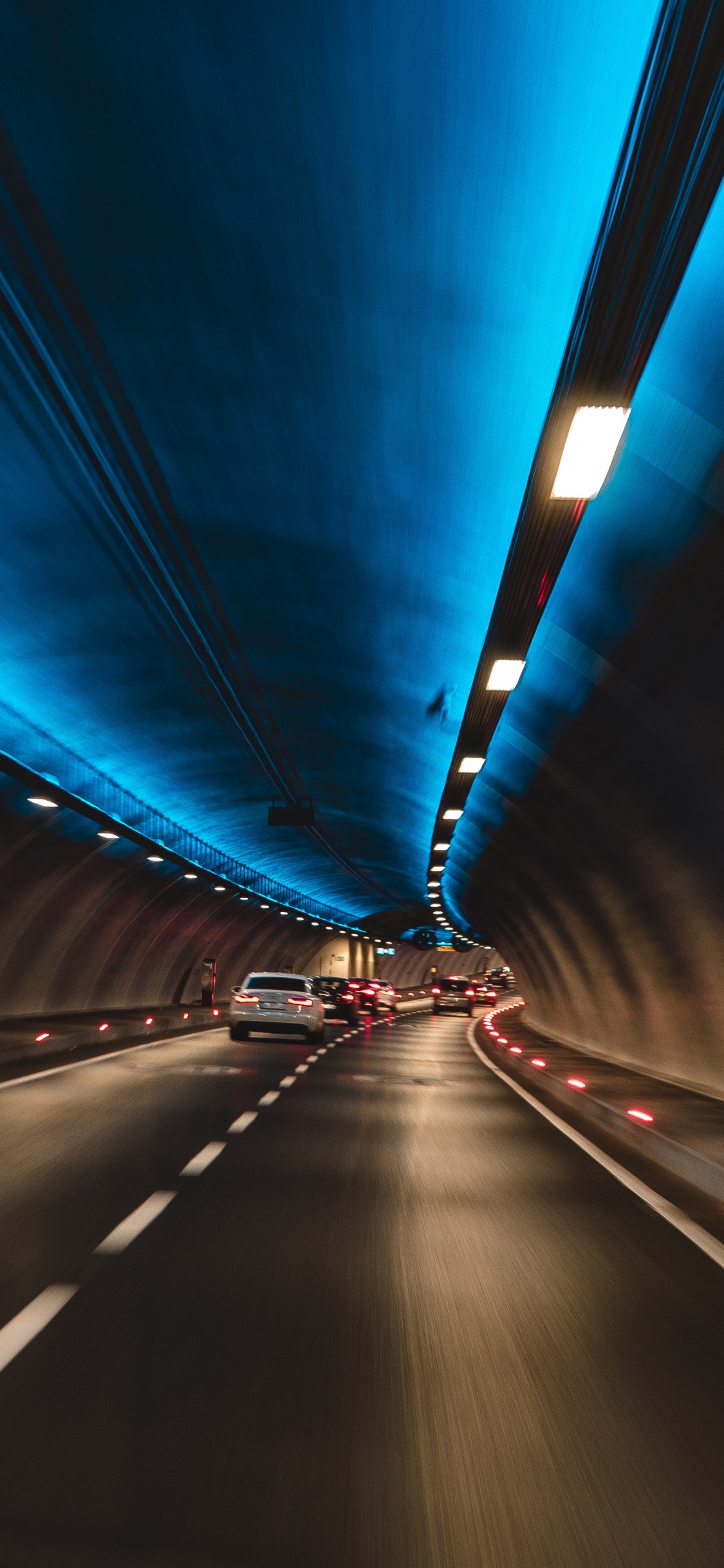 Blaues Licht im Tunnel Während Der Nacht. Wallpaper in 1125x2436 Resolution