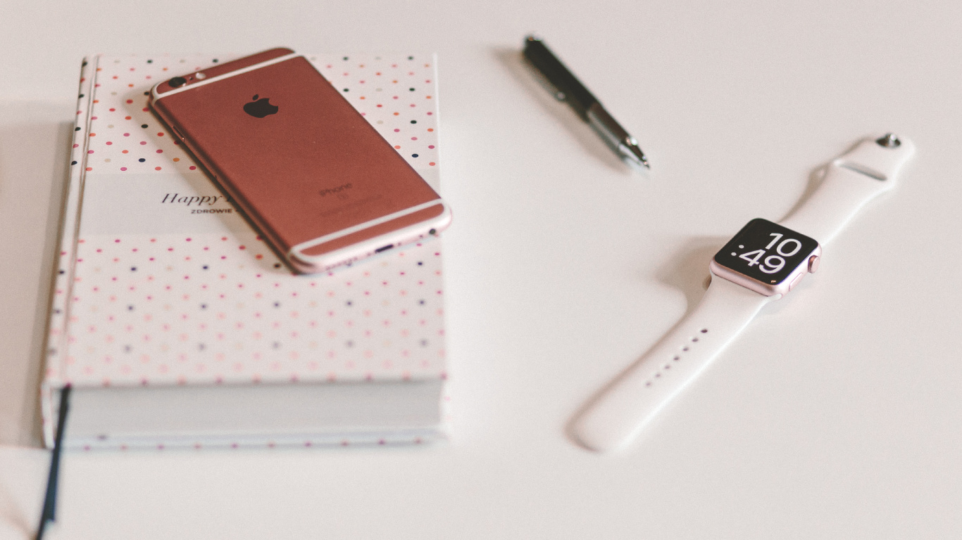 Silver Apple Watch With White Sport Band Beside Black Click Pen. Wallpaper in 1366x768 Resolution