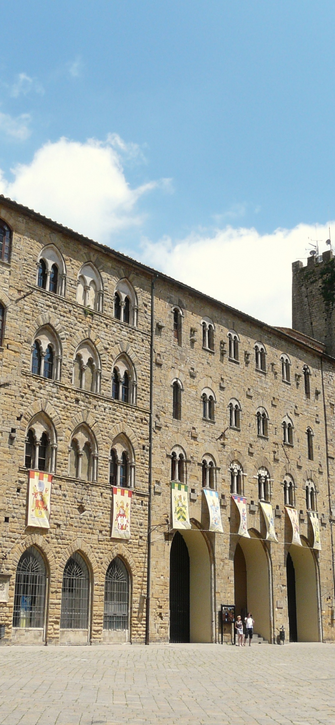 Coche Blanco Aparcado Junto al Edificio de Hormigón Marrón Durante el Día. Wallpaper in 1125x2436 Resolution