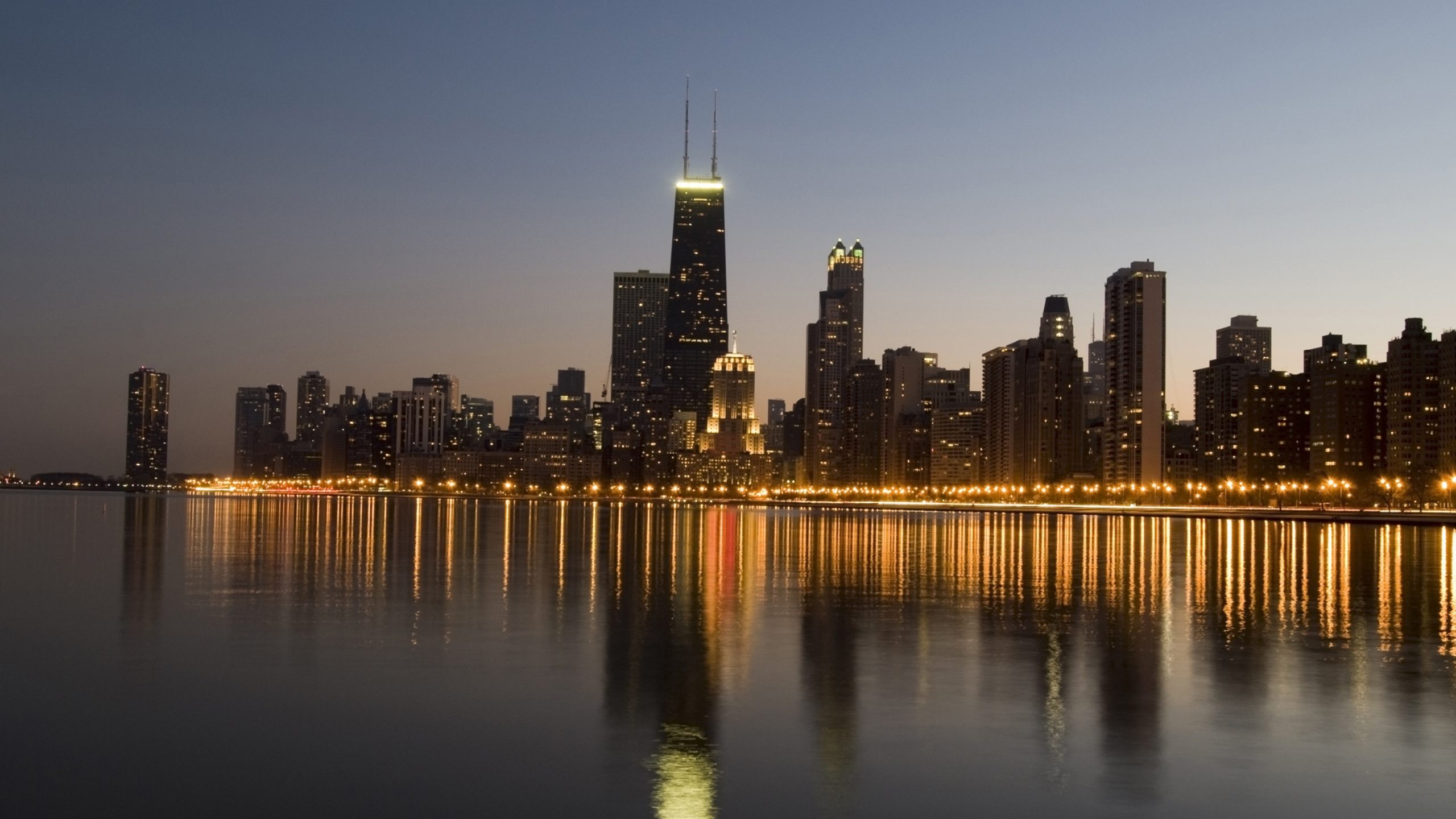 City Skyline Across Body of Water During Night Time. Wallpaper in 2560x1440 Resolution