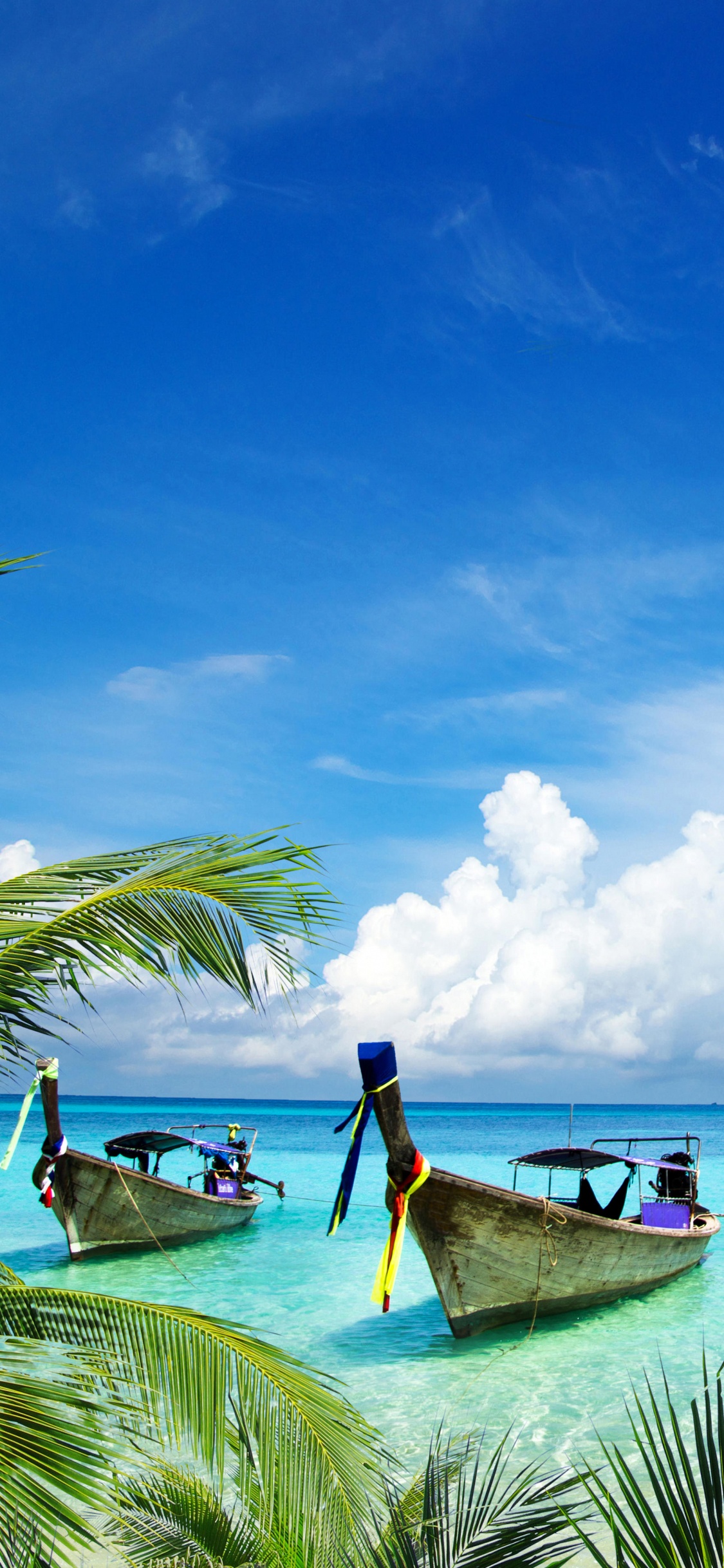Man Sitting on Brown Wooden Boat on Sea During Daytime. Wallpaper in 1125x2436 Resolution