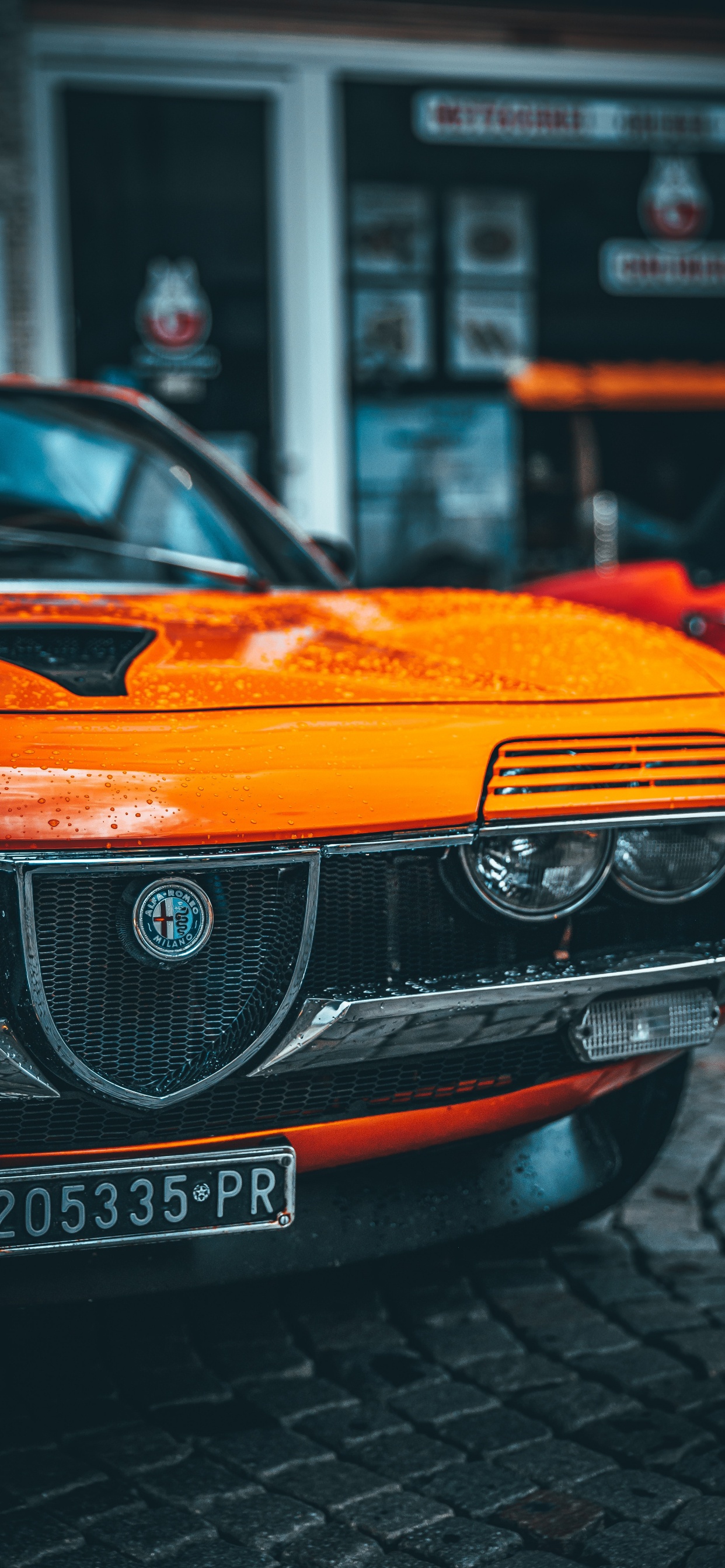 Orangefarbenes Bmw-auto Tagsüber Unterwegs. Wallpaper in 1242x2688 Resolution