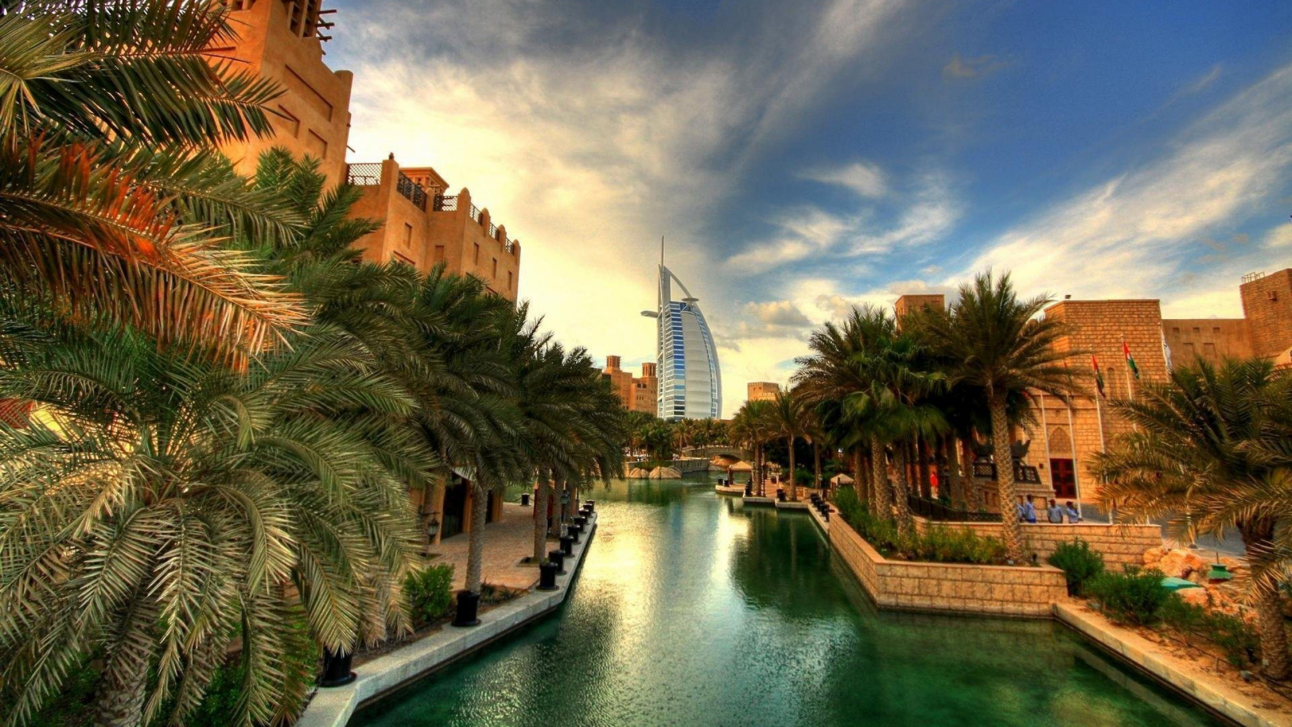 Braunes Betongebäude in Der Nähe Des Flusses Unter Blauem Himmel Tagsüber. Wallpaper in 2560x1440 Resolution