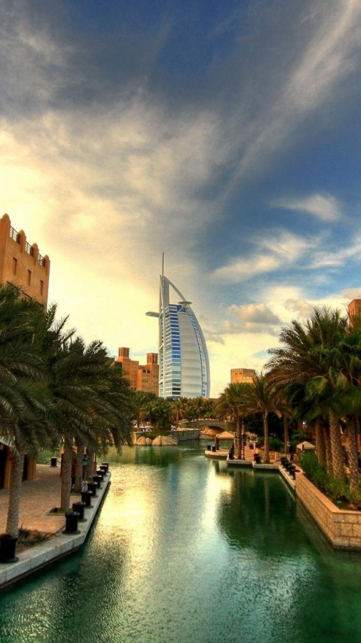 Braunes Betongebäude in Der Nähe Des Flusses Unter Blauem Himmel Tagsüber. Wallpaper in 720x1280 Resolution