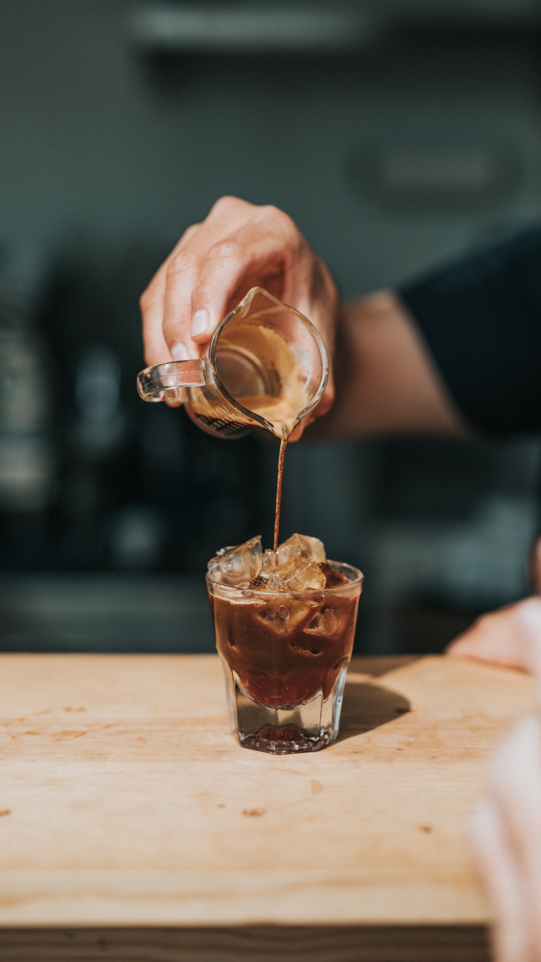 Person Pouring Brown Liquid on Clear Drinking Glass. Wallpaper in 1080x1920 Resolution