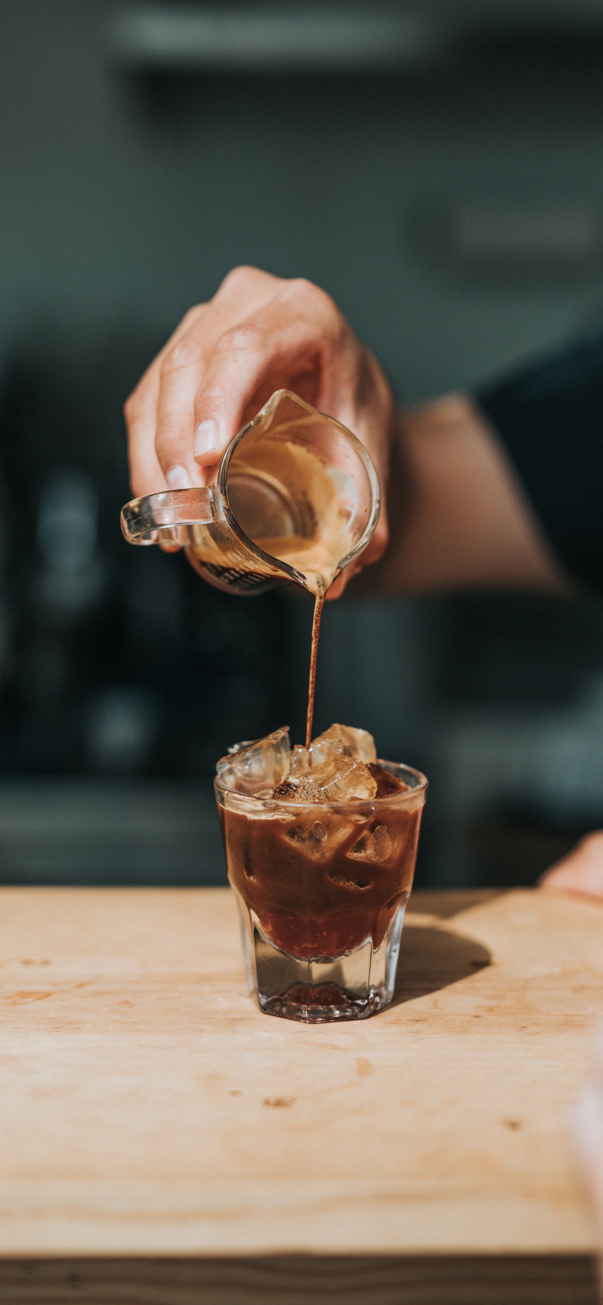 Person Pouring Brown Liquid on Clear Drinking Glass. Wallpaper in 1242x2688 Resolution