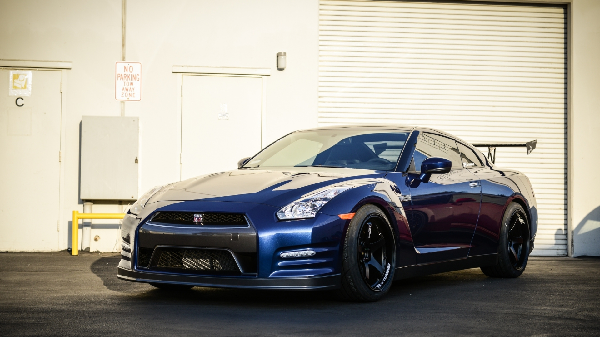 Bmw m 3 Coupe Azul Estacionado Cerca de la Puerta Enrollable Blanca. Wallpaper in 1920x1080 Resolution