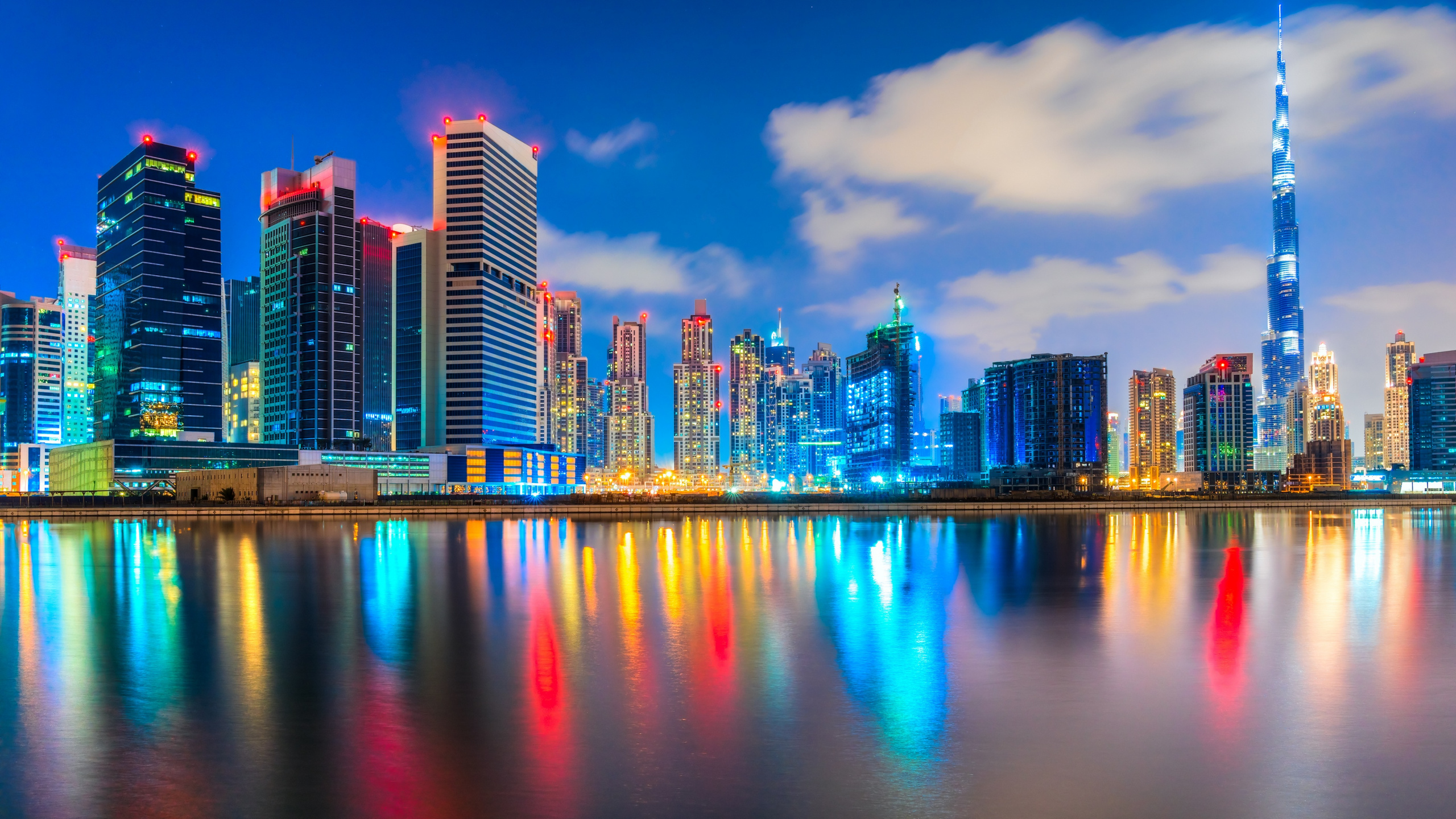 City Skyline Across Body of Water During Night Time. Wallpaper in 2560x1440 Resolution