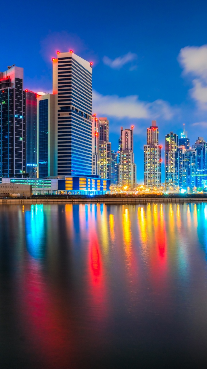 City Skyline Across Body of Water During Night Time. Wallpaper in 720x1280 Resolution