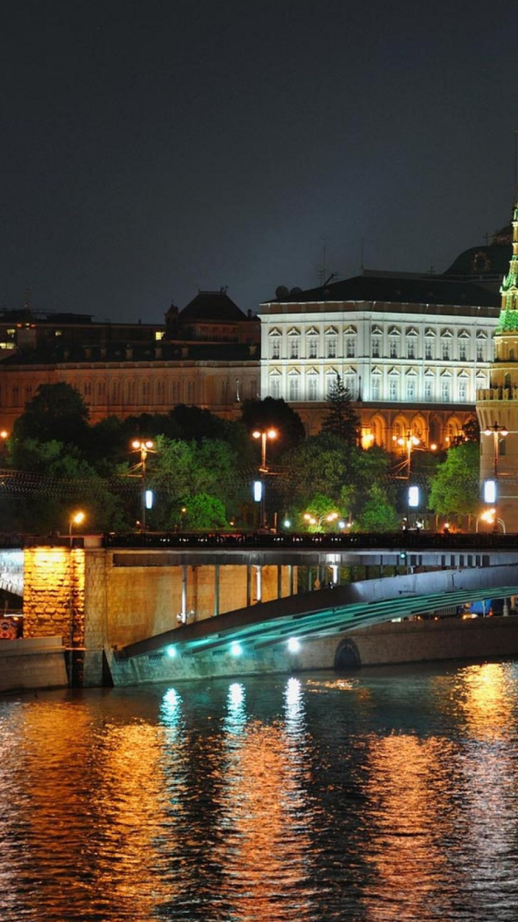 White Concrete Building Near Body of Water During Nighttime. Wallpaper in 750x1334 Resolution
