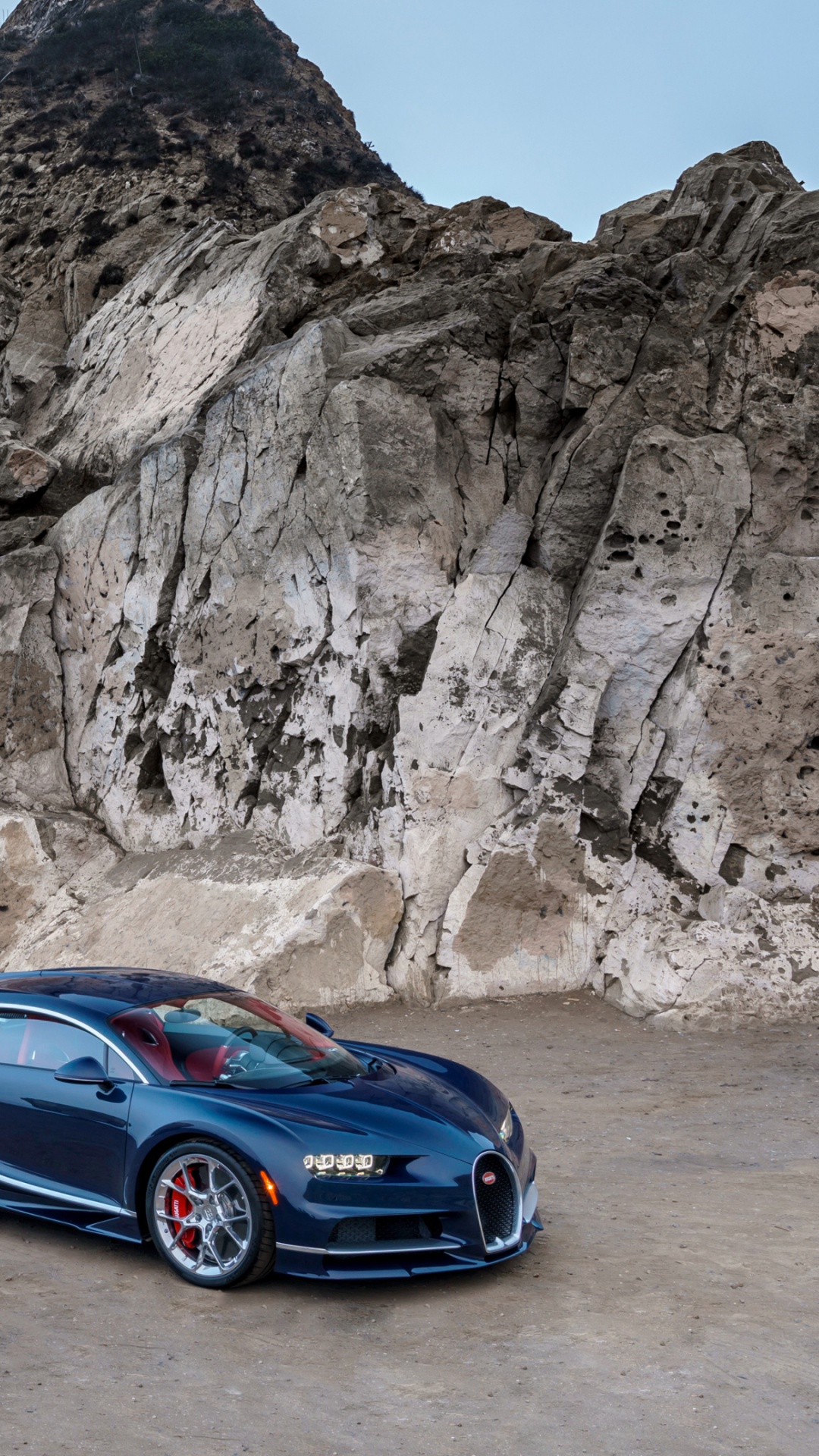 Blue Coupe on Gray Rocky Mountain During Daytime. Wallpaper in 1080x1920 Resolution