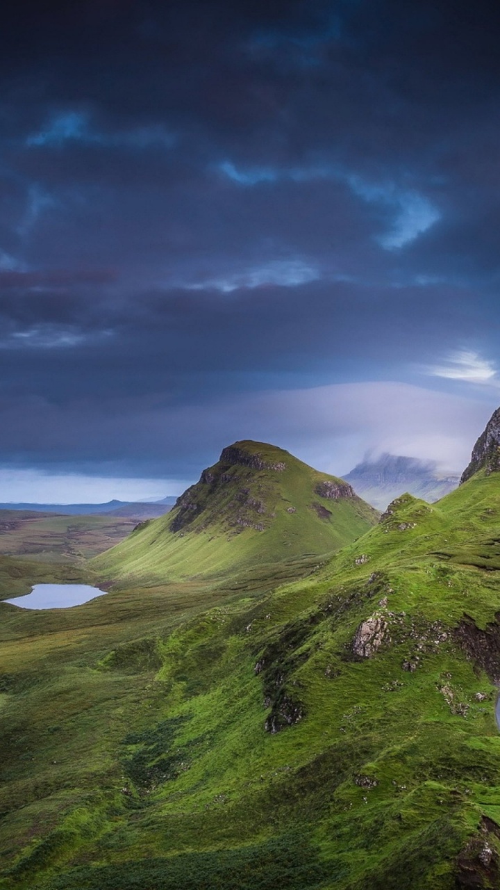 Campo de Hierba Verde Cerca Del Cuerpo de Agua Bajo un Cielo Nublado Durante el Día. Wallpaper in 720x1280 Resolution