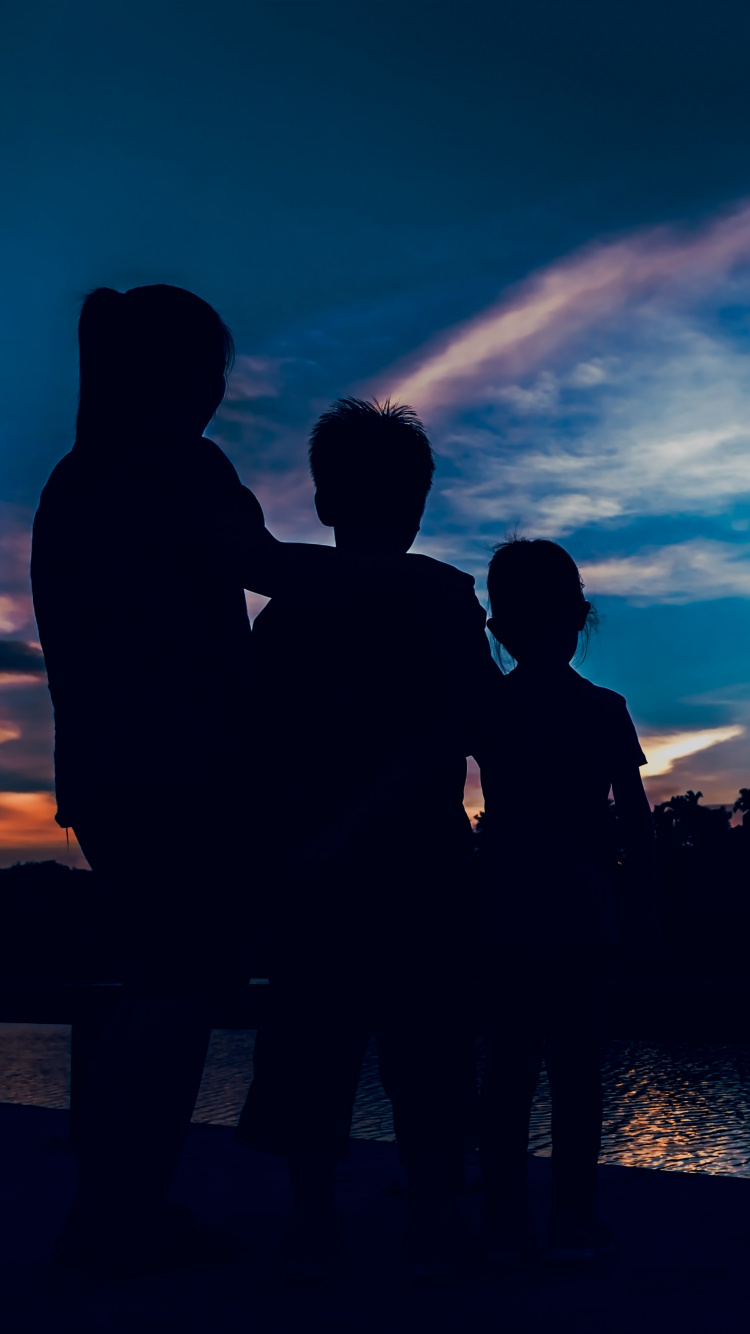Silhouette of People Standing Near Body of Water During Night Time. Wallpaper in 750x1334 Resolution