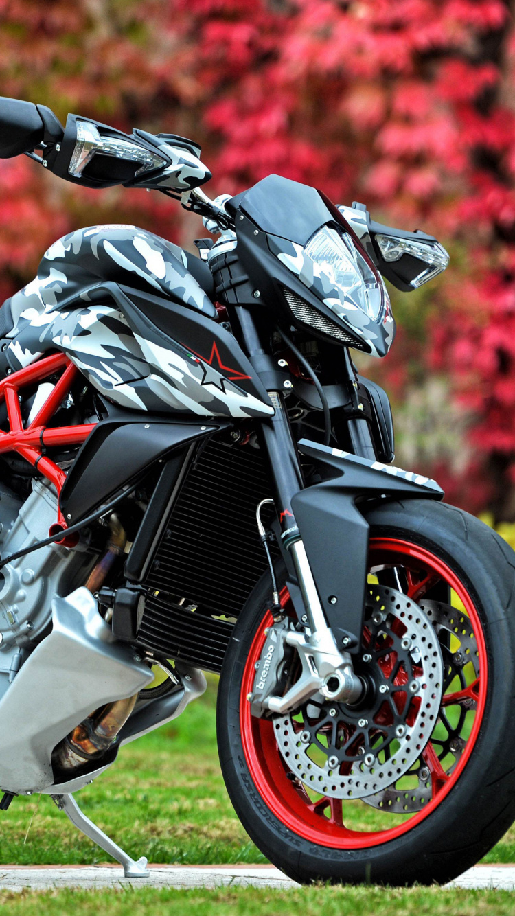 Black and Red Sports Bike on Green Grass Field During Daytime. Wallpaper in 750x1334 Resolution