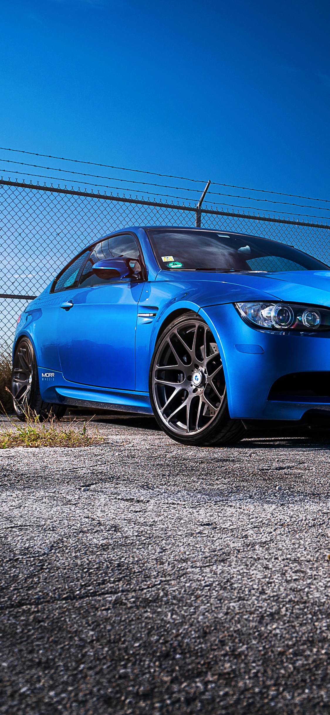 BMW m 3 Coupé Bleu Garé Sur Champ Brun Pendant la Journée. Wallpaper in 1125x2436 Resolution