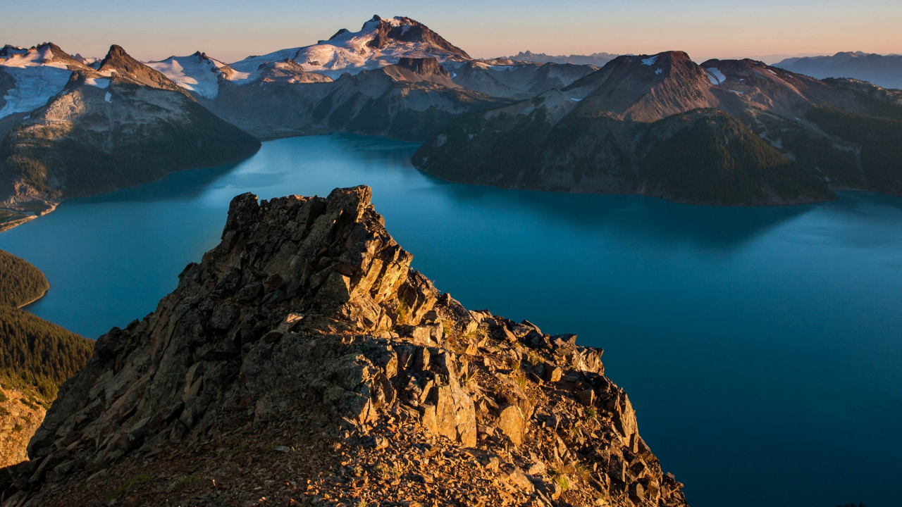 Brown Rocky Mountain Beside Blue Lake During Daytime. Wallpaper in 1280x720 Resolution