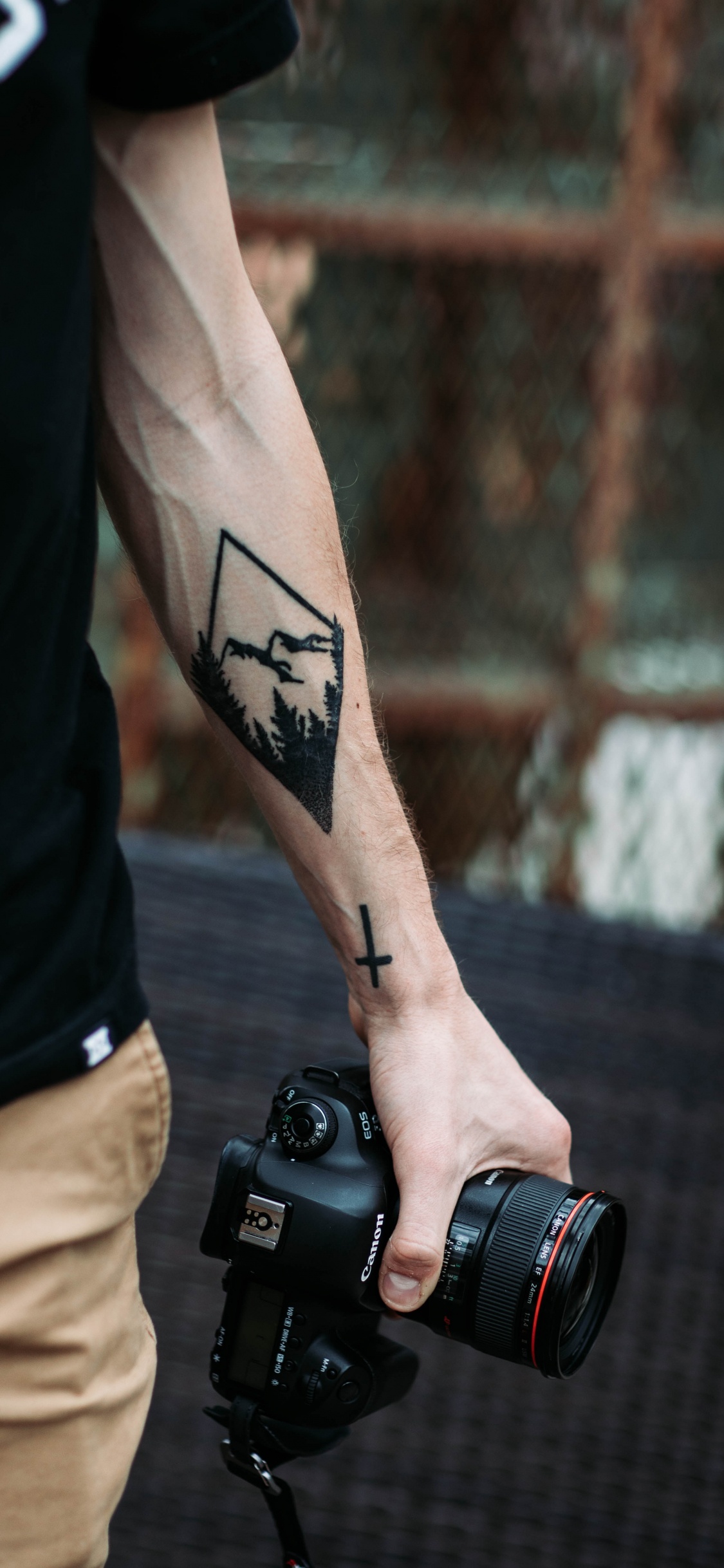 Mann im Schwarzen Tanktop Mit Schwarzer DSLR-Kamera. Wallpaper in 1125x2436 Resolution