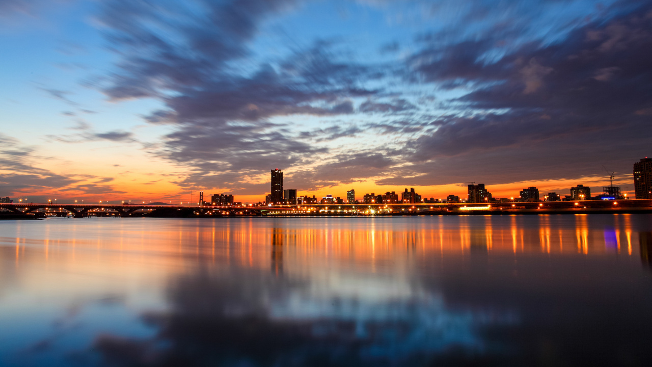 Horizon de la Ville à Travers le Plan D'eau Pendant le Coucher du Soleil. Wallpaper in 1280x720 Resolution