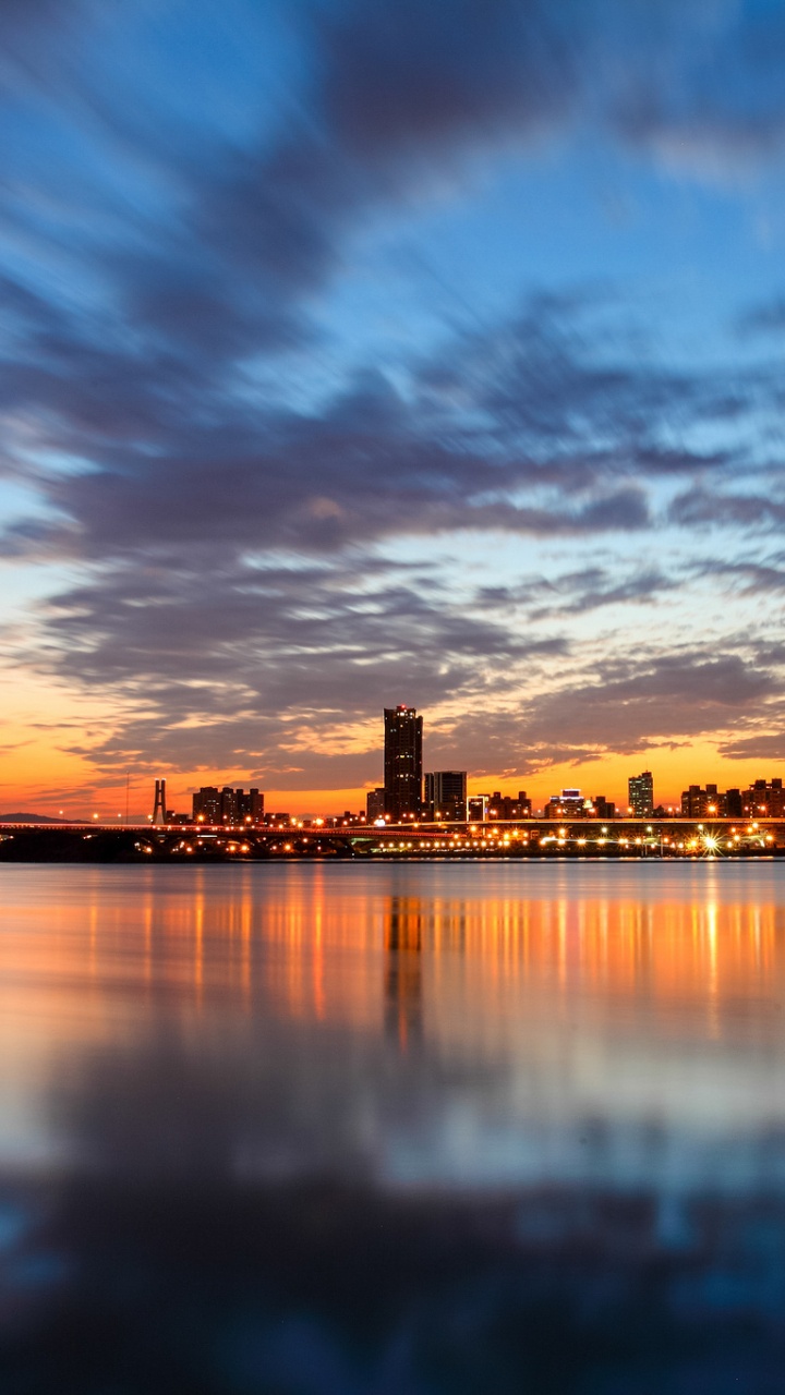 Horizon de la Ville à Travers le Plan D'eau Pendant le Coucher du Soleil. Wallpaper in 720x1280 Resolution