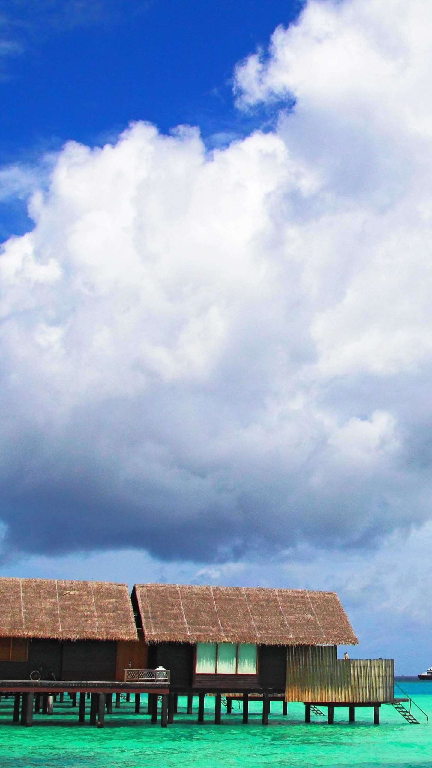 Maison en Bois Brune au Bord de la Mer Sous Les Nuages Blancs et le Ciel Bleu Pendant la Journée. Wallpaper in 1440x2560 Resolution